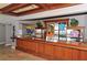 Luxurious bar featuring wood paneling, stone flooring, mirrored cabinets, and a decorative wood countertop at 3634 Torrey Pines Way Way, Sarasota, FL 34238