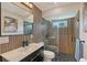 Modern bathroom with wood accent wall, glass shower and a stylish black vanity at 3634 Torrey Pines Way Way, Sarasota, FL 34238