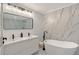 Bright bathroom features a soaking tub, double sink vanity, and marble-look tile at 3634 Torrey Pines Way Way, Sarasota, FL 34238