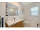 Bathroom with modern wood vanity, white counter, updated toilet and window at 3634 Torrey Pines Way Way, Sarasota, FL 34238
