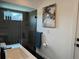 Modern bathroom featuring a sleek vanity, a tiled shower with a glass door, and beach-themed art at 3634 Torrey Pines Way Way, Sarasota, FL 34238