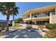 Elegant clubhouse with a covered entrance, surrounded by manicured landscaping and palm trees at 3634 Torrey Pines Way Way, Sarasota, FL 34238
