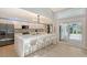 Modern kitchen with white cabinets, stainless steel appliances, large center island, and slider to backyard at 3634 Torrey Pines Way Way, Sarasota, FL 34238