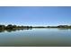 Scenic lake view reflecting the clear blue sky, with trees and homes dotting the distant shoreline at 3634 Torrey Pines Way Way, Sarasota, FL 34238