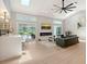 Bright living room featuring hardwood floors, fireplace, large sectional sofa, and access to the outdoor pool area at 3634 Torrey Pines Way Way, Sarasota, FL 34238