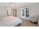 Bright main bedroom featuring light hardwood floors, decorative mirror, and access to private patio at 3634 Torrey Pines Way Way, Sarasota, FL 34238