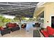 A covered outdoor patio furnished with sofas, chairs, and tables, perfect for relaxation and entertaining at 3634 Torrey Pines Way Way, Sarasota, FL 34238