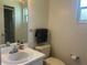 Bathroom featuring a white vanity, toilet, and window, complete with a towel rack and toilet paper holder at 4149 Prudence Dr, Sarasota, FL 34235