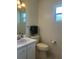 Bathroom featuring a white vanity, toilet, and window, complete with a towel rack and toilet paper holder at 4149 Prudence Dr, Sarasota, FL 34235