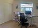 Bright bedroom featuring a large window, modern desk setup, and closet space, perfect for work and relaxation at 4149 Prudence Dr, Sarasota, FL 34235