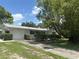 Inviting single-story home with a well-manicured lawn, attached garage and long driveway under a shady tree at 4149 Prudence Dr, Sarasota, FL 34235