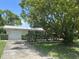 Inviting single-story home with a well-manicured lawn, attached garage and long driveway under a shady tree at 4149 Prudence Dr, Sarasota, FL 34235