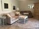 Inviting living room featuring a cozy sofa, decorative armoire, and a soft area rug on wood-look floors at 4149 Prudence Dr, Sarasota, FL 34235