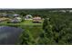 An aerial view of a spacious home with a large lot and mature trees, next to a beautiful lake at 4307 70Th E Ave, Ellenton, FL 34222
