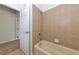 Bathroom showing the neutral colored tile continuing up the wall around the cream colored bathtub at 4307 70Th E Ave, Ellenton, FL 34222