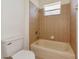 Bathroom featuring a bathtub with tile surround, shower head, toilet and small window at 4307 70Th E Ave, Ellenton, FL 34222