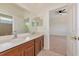 Bathroom with double sinks and wood cabinetry, view to bedroom at 4307 70Th E Ave, Ellenton, FL 34222