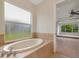 Bright bathroom showcasing a garden tub and a view to the main bedroom at 4307 70Th E Ave, Ellenton, FL 34222