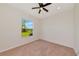 A bright bedroom featuring neutral carpeting and a window that overlooks the front yard at 4307 70Th E Ave, Ellenton, FL 34222