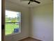 Neutral bedroom featuring a window that looks out onto a well-maintained yard with mature landscaping at 4307 70Th E Ave, Ellenton, FL 34222