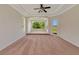 Carpeted bedroom featuring a tray ceiling, ceiling fan, and a door leading to outdoor views at 4307 70Th E Ave, Ellenton, FL 34222