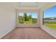 Sunlit bedroom with a scenic lake view, carpeted floors, and tray ceiling at 4307 70Th E Ave, Ellenton, FL 34222