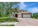 Two-story home featuring a brick driveway, 3 car garage, and arched entryway with a red front door at 4307 70Th E Ave, Ellenton, FL 34222