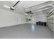 Spacious two car garage with grey epoxy flooring, white walls and door to the house at 4307 70Th E Ave, Ellenton, FL 34222