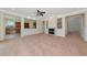 Bright, carpeted living room with fireplace, ceiling fan, and architectural columns at 4307 70Th E Ave, Ellenton, FL 34222