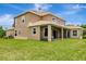Expansive green lawn with a view of the back of the home, which features a screened in patio at 4307 70Th E Ave, Ellenton, FL 34222