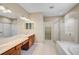 Bathroom featuring double sinks, tiled floors, glass shower, and a soaking tub at 4360 85Th Avenue E Cir, Parrish, FL 34219