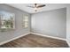 Bright bedroom featuring two windows, wood-look flooring, and modern ceiling fan at 4360 85Th Avenue E Cir, Parrish, FL 34219