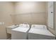 Functional laundry room equipped with a sink, washer, dryer, and upper shelving at 4360 85Th Avenue E Cir, Parrish, FL 34219