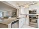 Stylish kitchen with stainless steel appliances, white cabinetry, and granite countertops at 4460 Fairways Blvd # 607, Bradenton, FL 34209