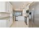 Bright kitchen with white cabinets, granite countertops, and stainless steel appliances overlooking living area at 4460 Fairways Blvd # 607, Bradenton, FL 34209
