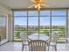 Enclosed lanai featuring outdoor seating and a panoramic view of the community's lush landscaping and a distant building at 4460 Fairways Blvd # 607, Bradenton, FL 34209