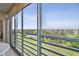 Relaxing screened lanai with panoramic views of a lush golf course, pond, and distant community buildings at 4460 Fairways Blvd # 607, Bradenton, FL 34209