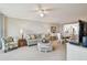Bright living room features a striped sofa, ceiling fan, and open access to the kitchen and dining area at 4460 Fairways Blvd # 607, Bradenton, FL 34209