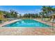 Relaxing pool with brick patio, comfortable lounge seating, and tropical landscaping at 4460 Fairways Blvd # 607, Bradenton, FL 34209
