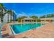 Community pool with brick paved deck, lounge chairs and tropical landscaping at 4460 Fairways Blvd # 607, Bradenton, FL 34209