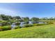 Lush green lawn leading to a serene lake with a clear blue sky at 4487 Cinnamon Dr # 2604, Sarasota, FL 34238
