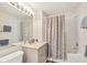 Bright bathroom with a marble vanity, elegant fixtures, and patterned shower curtain at 4487 Cinnamon Dr # 2604, Sarasota, FL 34238