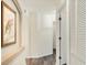 Neutral hallway with wood look flooring, artwork, and a convenient laundry closet at 4487 Cinnamon Dr # 2604, Sarasota, FL 34238
