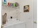 Convenient laundry area with white appliances and storage shelving at 4487 Cinnamon Dr # 2604, Sarasota, FL 34238