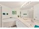 Spa-like main bathroom with a soaking tub, double vanity, and a separate glass shower at 4487 Cinnamon Dr # 2604, Sarasota, FL 34238