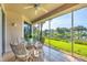 Relaxing screened patio with ceiling fan, dining set, and a serene lake view at 4487 Cinnamon Dr # 2604, Sarasota, FL 34238