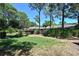 Landscaped backyard featuring mature trees, lush lawn, and manicured bushes at 4555 Chandlers Forde # 47, Sarasota, FL 34235