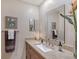 Bathroom featuring marble countertop, modern decor, framed art, and large mirror at 4555 Chandlers Forde # 47, Sarasota, FL 34235
