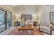 Bright living room boasts a tile floor, outdoor view, comfortable chairs, and wall decor at 4555 Chandlers Forde # 47, Sarasota, FL 34235