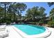 Community pool surrounded by lush landscaping and mature trees for resident enjoyment at 4555 Chandlers Forde # 47, Sarasota, FL 34235